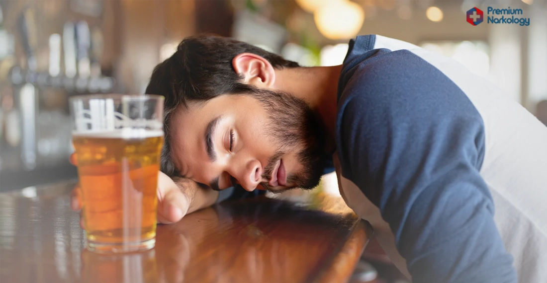 мужчина с кружкой пива спит за барной стойкой